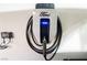 Close-up of a Ford electric vehicle charging station mounted on a white wall, with a neat cable arrangement at 8113 Misty Canyon Ave, Las Vegas, NV 89113