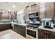 Modern kitchen with dark cabinets, stainless steel appliances, and tile backsplash at 8113 Misty Canyon Ave, Las Vegas, NV 89113