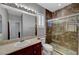 Bathroom featuring a vanity, toilet, and tiled shower with glass door at 8409 Insignia Ave # 102, Las Vegas, NV 89178