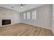 Bright living room with stylish wood floors, a stone fireplace, and multiple windows at 8409 Insignia Ave # 102, Las Vegas, NV 89178
