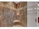 Modern shower with tile surround, corner seat, and a glass door at 8409 Insignia Ave # 102, Las Vegas, NV 89178