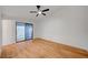 Bright bedroom featuring wood-look flooring, a ceiling fan, and sliding glass door access to the outside at 8412 Mulcahy Ave, Las Vegas, NV 89145