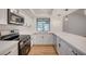 Bright kitchen with white cabinets, stainless steel appliances, updated fixtures, and wood-look flooring at 8412 Mulcahy Ave, Las Vegas, NV 89145