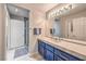 Bathroom features quartz countertops, blue vanity, and a walk-in shower with glass door at 91 E Agate Ave # 204, Las Vegas, NV 89123