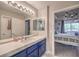 Bathroom with blue vanity, quartz countertop, and doorway view into bedroom at 91 E Agate Ave # 204, Las Vegas, NV 89123