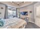 Contemporary bedroom boasts a private balcony, TV, and modern lighting fixture at 91 E Agate Ave # 204, Las Vegas, NV 89123