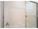 Tiled bathtub shower combo with glass doors and a shower head at 9289 Mandeville Bay Ave, Las Vegas, NV 89148