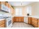 Bright kitchen with wooden cabinets, tile floors, white appliances, and large countertops at 9289 Mandeville Bay Ave, Las Vegas, NV 89148
