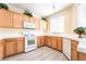Well-lit kitchen features modern white appliances, wood cabinets, and tiled countertops at 9289 Mandeville Bay Ave, Las Vegas, NV 89148