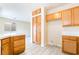 A bright kitchen features wood cabinets, tiled counters, and a view into another room at 9289 Mandeville Bay Ave, Las Vegas, NV 89148