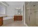 Bathroom featuring a soaking tub, glass-enclosed shower, and wood vanity at 936 Viscanio Pl, Las Vegas, NV 89138