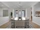 Bright and airy dining room with modern chandelier and adjacent open kitchen and outside views at 936 Viscanio Pl, Las Vegas, NV 89138