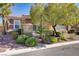 Charming single-story home featuring stone accents and mature landscaping, complemented by vibrant green foliage at 936 Viscanio Pl, Las Vegas, NV 89138