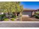 Charming single-story home featuring a two-car garage, stone accents, and mature landscaping at 936 Viscanio Pl, Las Vegas, NV 89138
