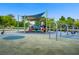 Community playground with slides and swings set against a backdrop of lush trees and blue sky at 936 Viscanio Pl, Las Vegas, NV 89138