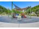 Community playground with a shaded play structure, multiple slides, and soft ground covering at 936 Viscanio Pl, Las Vegas, NV 89138