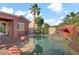 Backyard pool with rock features, alongside lush landscaping and home's exterior at 936 Viscanio Pl, Las Vegas, NV 89138