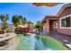 Amazing backyard features a pool, waterfall, outdoor kitchen, and a covered patio for entertaining at 936 Viscanio Pl, Las Vegas, NV 89138
