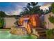Captivating pool with a rock waterfall feature, surrounded by lush landscaping for a tropical oasis at 936 Viscanio Pl, Las Vegas, NV 89138