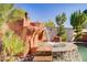 Backyard retreat featuring a rock waterfall and a sparkling pool surrounded by lush palms at 936 Viscanio Pl, Las Vegas, NV 89138