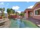 Sparkling pool alongside the home, featuring an outdoor kitchen and lush landscaping at 936 Viscanio Pl, Las Vegas, NV 89138