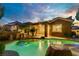 Back exterior of house, with large rock pool surrounded by palm trees at 936 Viscanio Pl, Las Vegas, NV 89138
