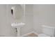 Cozy powder room with a pedestal sink, round mirror, toilet, and tile flooring for a classic, minimalist style at 936 Viscanio Pl, Las Vegas, NV 89138