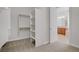 Spacious walk-in closet with built-in shelving and carpeted floor, located next to a bathroom with a warm vanity at 936 Viscanio Pl, Las Vegas, NV 89138