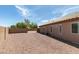 Expansive backyard area featuring gravel landscaping, block wall, and building elevation at 9524 Tyler Rose St, Las Vegas, NV 89178