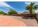 The backyard has a gravel yard, a block wall, a red cement patio, and a palm tree at 9524 Tyler Rose St, Las Vegas, NV 89178