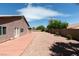 The large backyard features a block wall, a red cement patio, gravel, and desert landscaping at 9524 Tyler Rose St, Las Vegas, NV 89178