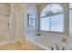 Relaxing bathroom features a garden tub, tiled shower, and large window with filtered light at 9524 Tyler Rose St, Las Vegas, NV 89178