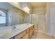 Bright bathroom boasts a double sink vanity, expansive mirror, and a glass-enclosed shower at 9524 Tyler Rose St, Las Vegas, NV 89178
