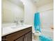 Bright bathroom featuring a shower-tub combo with blue curtain, a white countertop, and dark wood cabinetry at 10204 Kern Peak St, Las Vegas, NV 89166