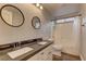 Bathroom featuring dual sinks, dark counters and wood floors at 10311 Slope Ridge St, Las Vegas, NV 89131