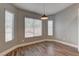 Cozy dining area featuring three windows, wood-look flooring, and modern lighting at 10311 Slope Ridge St, Las Vegas, NV 89131