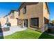 Backyard features a patio set, grill, artificial grass, brick wall, and the home's exterior at 10939 Cheshire Woods Ave, Las Vegas, NV 89166