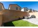Backyard features a patio set, grill, artificial grass, and a brick wall at 10939 Cheshire Woods Ave, Las Vegas, NV 89166