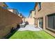 Backyard features a patio set, grill, artificial grass, and a brick wall at 10939 Cheshire Woods Ave, Las Vegas, NV 89166