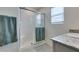 Bathroom showcasing a tiled shower with glass doors and a granite countertop at 10939 Cheshire Woods Ave, Las Vegas, NV 89166
