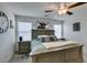 Bedroom features a ceiling fan, large bed, two windows, and modern wall decor at 10939 Cheshire Woods Ave, Las Vegas, NV 89166