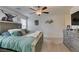 Bedroom featuring a ceiling fan, large bed, dresser with TV and wall decor at 10939 Cheshire Woods Ave, Las Vegas, NV 89166
