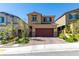 Charming two-story home featuring a red garage door, desert landscaping, and a brick-paved driveway at 10939 Cheshire Woods Ave, Las Vegas, NV 89166