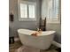Luxurious bathroom with modern freestanding tub and wood look tile floors at 11201 Newbury Hills Ave, Las Vegas, NV 89138