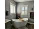 Bright bathroom showcasing a modern freestanding tub, wood look floors, and gray accents at 11201 Newbury Hills Ave, Las Vegas, NV 89138