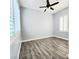 This bedroom offers wood floors, a ceiling fan, and a window with white shutters at 11201 Newbury Hills Ave, Las Vegas, NV 89138