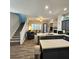 Open floor plan with stairs, living room, and kitchen with stainless appliances and breakfast bar at 11201 Newbury Hills Ave, Las Vegas, NV 89138