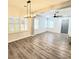 Bright, open living room with wood floors and modern lighting fixture with shuttered windows at 11201 Newbury Hills Ave, Las Vegas, NV 89138