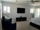 Spacious main bedroom featuring plush seating, a large flat-screen TV, and neutral decor at 11201 Newbury Hills Ave, Las Vegas, NV 89138