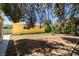 Spacious backyard with yellow exterior and mature trees at 1127 Melville Dr, Las Vegas, NV 89102